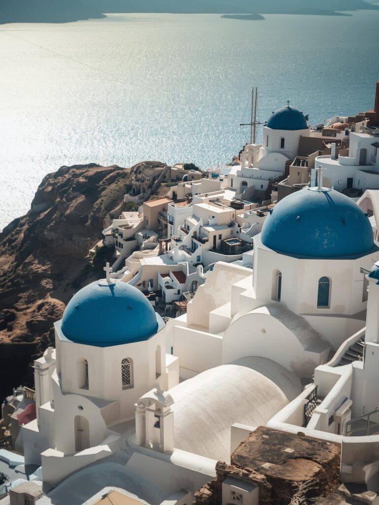 the island of santorini is famous for its whitewashed houses and blue domed churches overlooking the aegean sea, summer sunny day, bird view